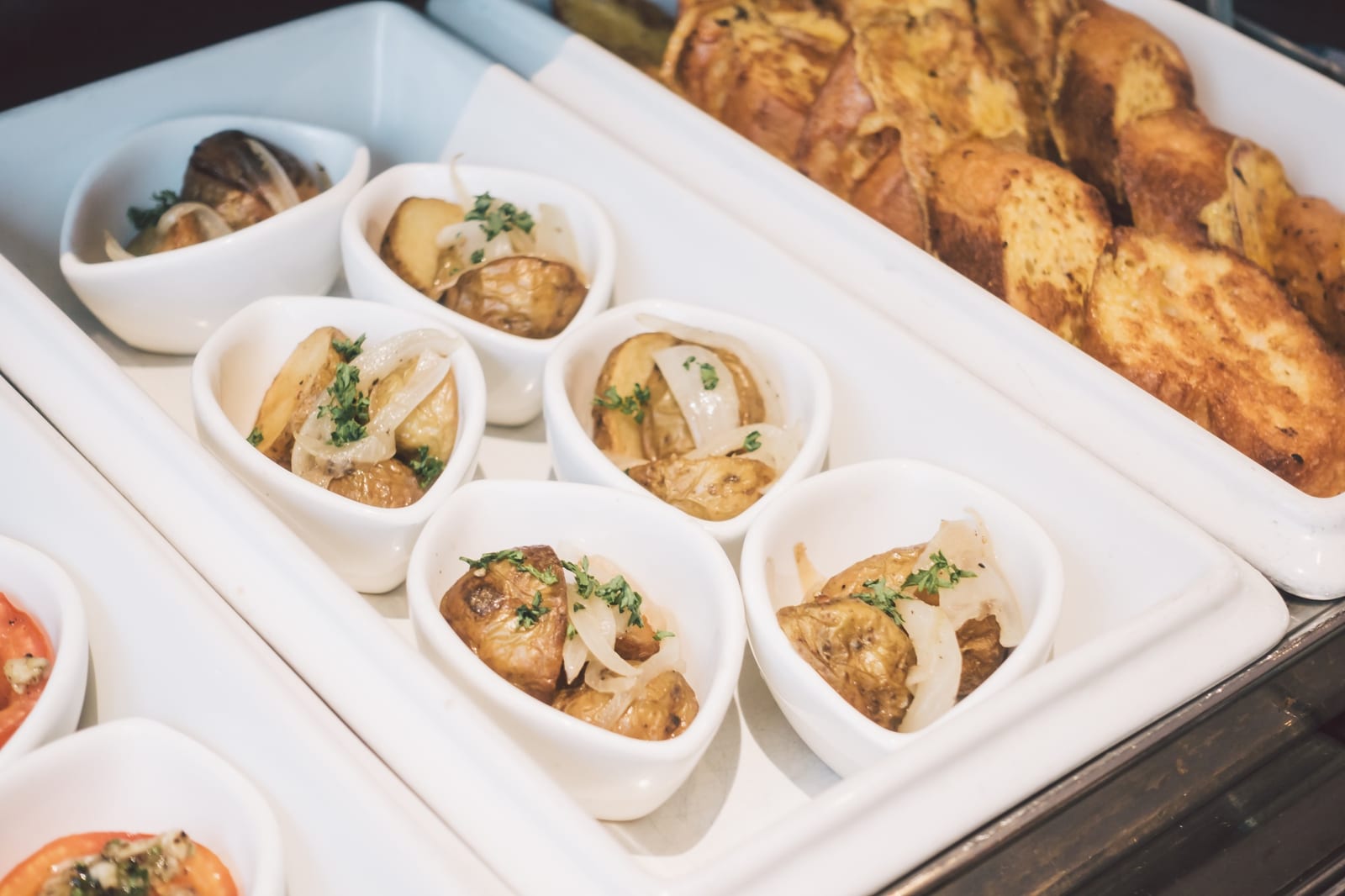 Mesa de buffet organizada com travessas para evento corporativo